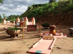 um parque infantil com um pequeno castelo na areia em Auberge Les Hauts De Chenas em Chénas