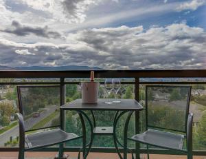 una mesa y dos copas de vino en un balcón en Playa Del Sol Resort - Vacation Rentals, en Kelowna
