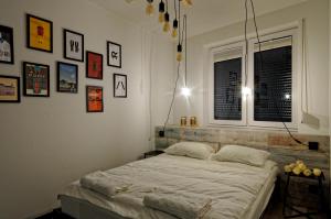 - une chambre avec un lit et des photos sur les murs dans l'établissement Industrialny Kwadrat, à Złotów