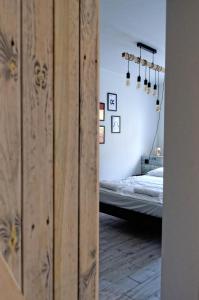 sypialnia z łóżkiem i drewnianą ścianą w obiekcie Industrialny Kwadrat w mieście Złotów