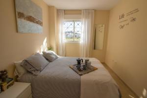 アルガロボ・コスタにあるBarlovento & Beachのベッドルーム1室(トレイ付きベッド1台付)