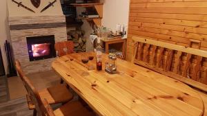 una mesa de madera en una habitación con chimenea en Krpáčovo, Nízke Tatry - chata na kraji lesa en Dolná Lehota