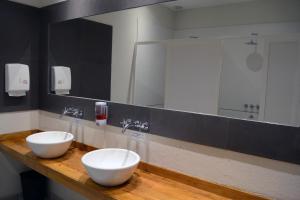 a bathroom with two white bowls on a wooden counter at Posada del Blanco in Potrerillos