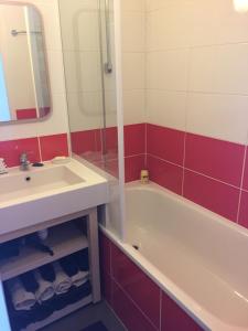 uma casa de banho com um lavatório e uma banheira em F2 résidence Antarès em Avoriaz