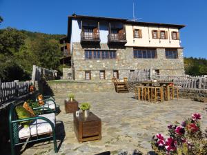 een groot stenen gebouw met een patio ervoor bij Sintrivanis Mountain in Áno Skotína