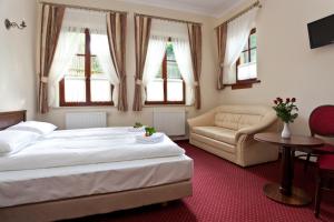 sypialnia z łóżkiem, kanapą i oknami w obiekcie Pensjonat Czardasz w mieście Niedzica Zamek