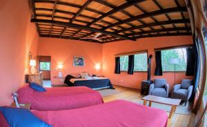 een woonkamer met 2 bedden en een slaapkamer bij El Soberbio Lodge in El Soberbio