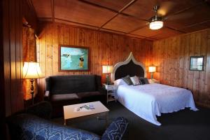 a bedroom with a bed and a chair and a couch at McMenamins Gearhart Hotel in Gearhart