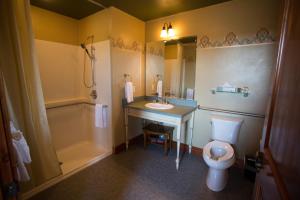 ein Badezimmer mit einem Waschbecken, einem WC und einer Badewanne in der Unterkunft McMenamins Gearhart Hotel in Gearhart