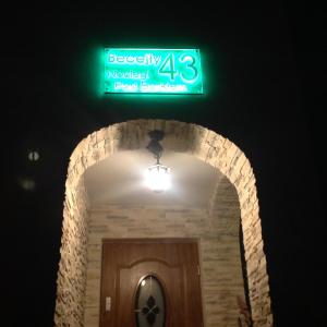 a green street sign above a doorway with a door at Noclegi Pod Borkiem in Szypliszki