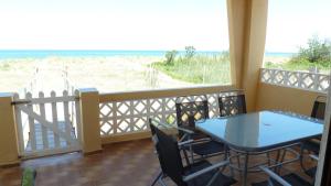 balkon ze stołem i krzesłami oraz widokiem na plażę w obiekcie Casa Playa w mieście Tavernes de Valldigna