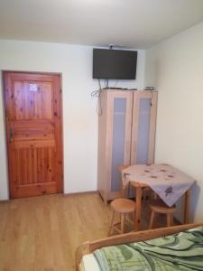 Habitación con mesa, cama y puerta en Zawoja Pod Grapą, en Zawoja