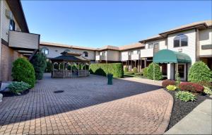 un patio de un edificio con cenador en Roosevelt Inn & Suites Saratoga Springs, en Saratoga Springs