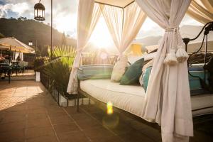 Dormitorio con cama con dosel y sol en el fondo en Hotel Boutique Los Pasos & Spa, en Antigua Guatemala