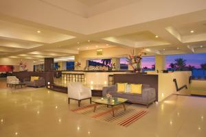 a lobby with couches and a table and a bar at Dreams Huatulco Resort & Spa in Santa Cruz Huatulco