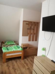 a small bedroom with a bed and a flat screen tv at Zawoja Pod Grapą in Zawoja