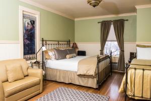 a bedroom with a bed and a chair and a window at Chamberlin Inn in Cody