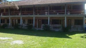 ein großes Gebäude mit Rasen davor in der Unterkunft Guerreiro Sui­tes in Boicucanga