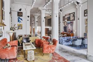 a lobby with red chairs and tables in a building at San Francisco Proper Hotel, a Member of Design Hotels in San Francisco