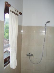 a bathroom with a shower with a shower curtain at Bubu Racok Homestay in Amed