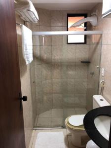 een badkamer met een douche, een toilet en een wastafel bij Atlântico Flat 104 e 116 in Natal