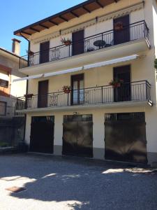 a white building with black gates and balconies at Betty's House in Mandello del Lario