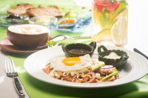 a plate of food with an egg on a table at Hotel Villa Mozart y Macondo in Puerto Escondido