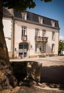 een groot wit gebouw voor een straat bij La Glycinière Chambres d'Hôtes in Pont-Croix