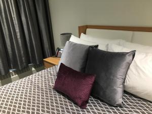 a bed with three pillows on top of it at University of Alberta - PLH Accommodation in Edmonton