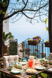a wooden table with plates of food on it at Villa Laura amazing breakfast,private outdoor hot tub, Positano experience in Positano