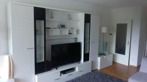 a living room with a large entertainment center with a flat screen tv at Ferienappartement Feldstrasse in Winterberg