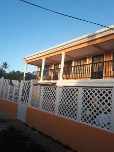 uma casa com uma cerca branca em frente em Miss Leila em San Andrés