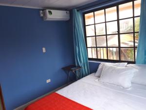 聖安德烈斯的住宿－Miss Leila，蓝色的客房设有床和窗户。