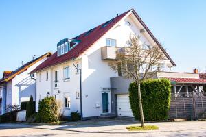 a white house with a red roof at Apartment D&D Spessart in Ettlingen