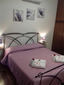 ヴィテルボにあるB&B Le Cinque Querceのベッドルーム1室(紫色のベッド1台、タオル2枚付)