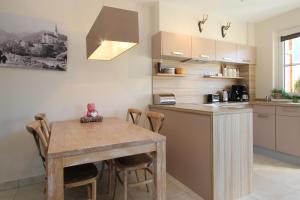 a kitchen with a wooden table and a dining room at AvenidA Residenz an der Burg by Alpin Rentals in Kaprun
