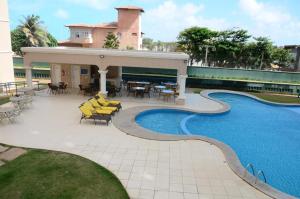 a resort with a swimming pool and tables and chairs at Apartamento Praia do futuro Bech Village in Fortaleza