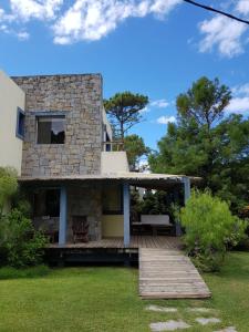 Casa de piedra con terraza de madera en el patio en Entre Faros, en Punta del Este