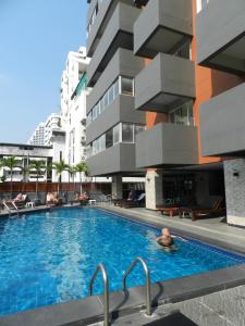 a man in a swimming pool next to a building at Nanatai Suites in Bangkok