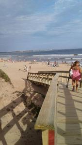 una mujer de pie junto a un banco en una playa en Casa en la playa, en Maldonado