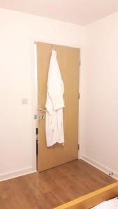 a white shirt hanging on a door in a room at Lavi's house-East Milton Keynes in Milton Keynes