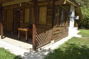 Cabaña de madera con mesa en el porche en Villas Maria Luisa, en Uvita