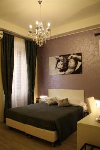 a bedroom with a bed and a chandelier at Residenza Elizabeth in Rome