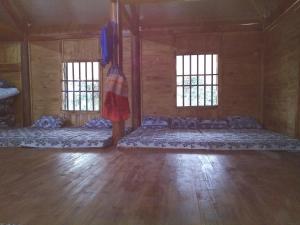 a large room with two beds and two windows at Flower hmong homestay in Bắc Hà