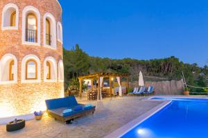 une maison avec une piscine à côté d'un bâtiment dans l'établissement Villa Can Señora, à Sant Antoni de Portmany