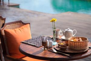 a wooden table with a tea set on top of it at Natya Resort Ubud in Ubud