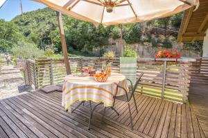 a table with an umbrella on a wooden deck at Sweet Laghel Apartments in Arco