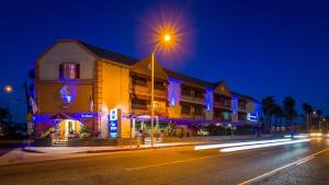 a building on a city street at night at Best Western Harbour Inn & Suites Huntington - Sunset Beach in Huntington Beach