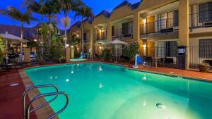 Best Western Palm Garden Inn في ويستمنستر: وجود مسبح في الفندق ليلا