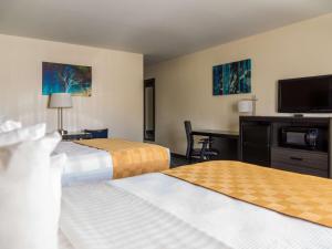 a hotel room with two beds and a flat screen tv at Best Western Alamosa Inn in Alamosa